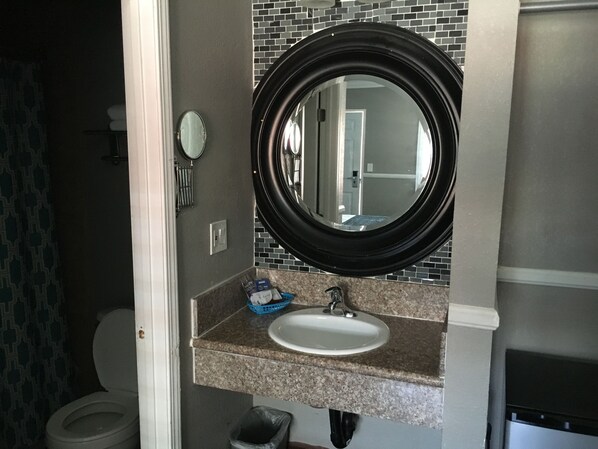Un baño con lavabo, espejo y retrete.