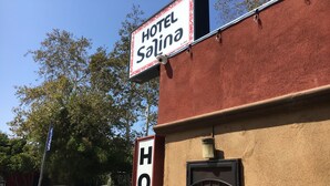 Um letreiro de hotel com o nome 'Hotel Salina' e uma placa 'HOTEL' abaixo.