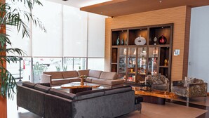 Een moderne woonkamer met een modulaire bank, een salontafel en een houten kast met decoratieve objecten.