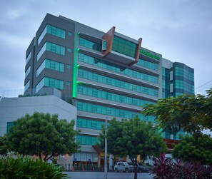 A modern building with a prominent 'Holiday Inn' sign, multiple floors, and a glass facade. - Holiday Inn Guayaquil Airport by IHG (Guayaquil)