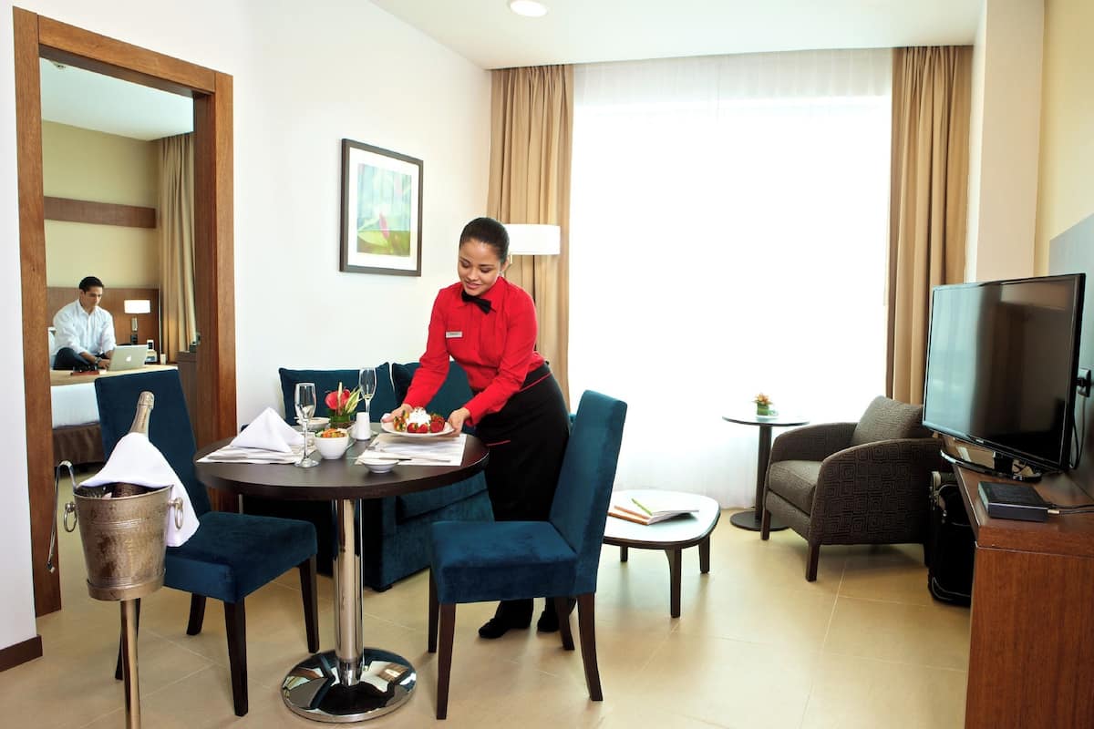 Een hotelkamer met een zithoek, een televisie en een bed.
