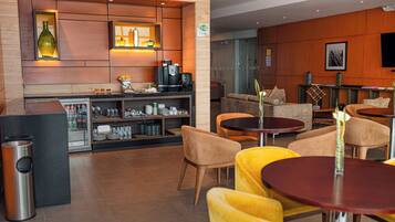 Un área de bar moderna con asientos y una cafetera.