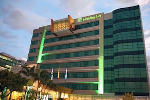 A multi-story Holiday Inn hotel with a modern design, featuring a prominent logo on the top.