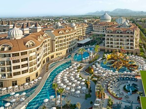 Um hotel com vários edifícios, uma piscina grande e parque aquático.