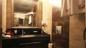 A bathroom with a sink, mirror, toilet, and towel rack.
