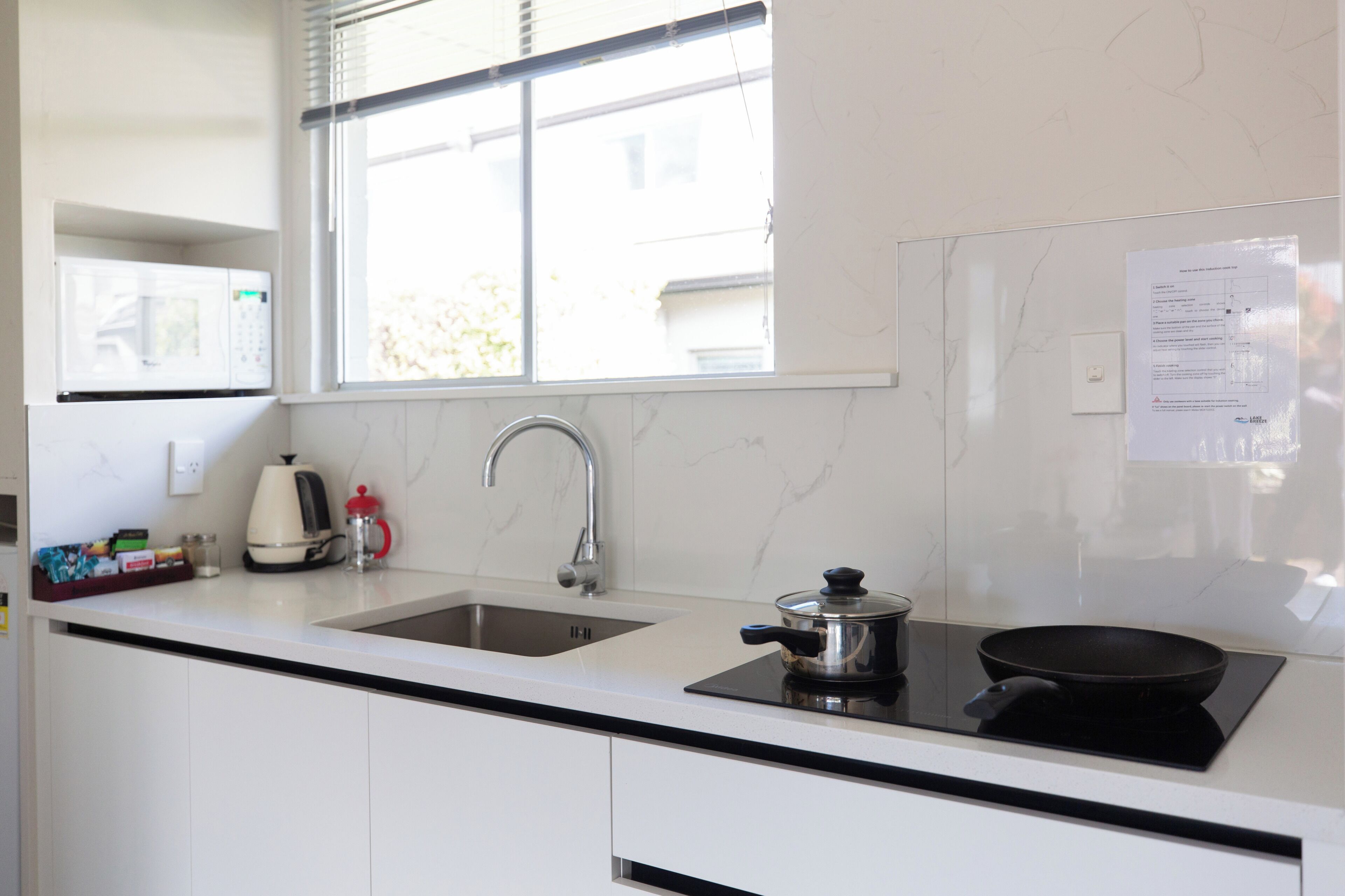 A modern kitchen with a double sink, a stove, and a window above the sink.