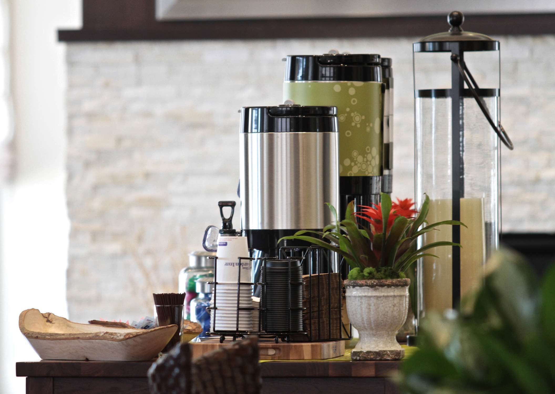 Una encimera de cocina con una cafetera, un hervidor y una tetera.