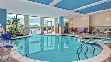 Una piscina techada, una piscina al aire libre, sombrillas