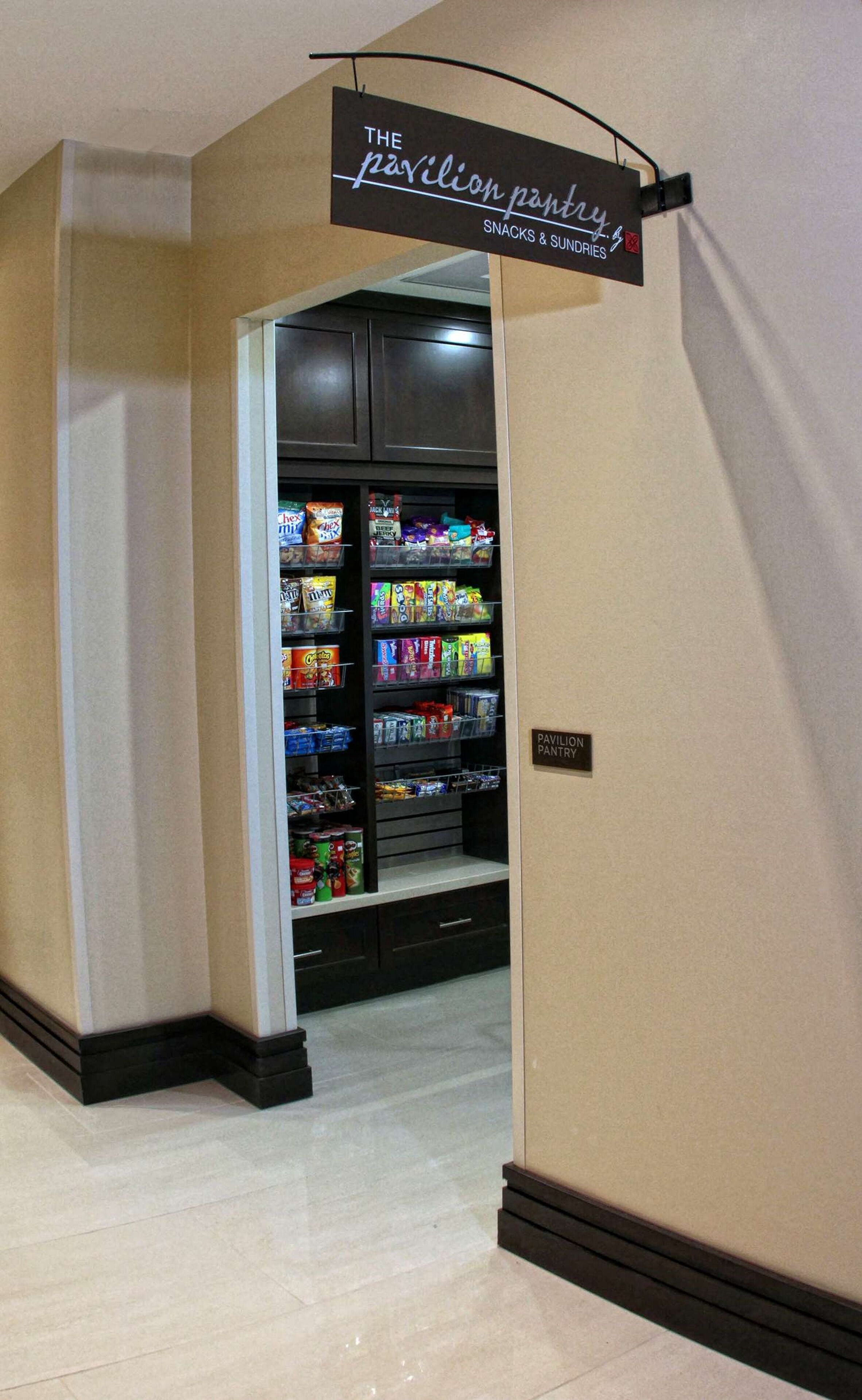 A hallway leading to a snack and sundries section with a sign above it.