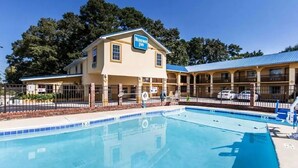 A hotel with a pool, a sign reading "Baker's Inn," and a two-story building with a blue roof. - Days Inn by Wyndham Calhoun GA I-75 and US-41 (Calhoun)