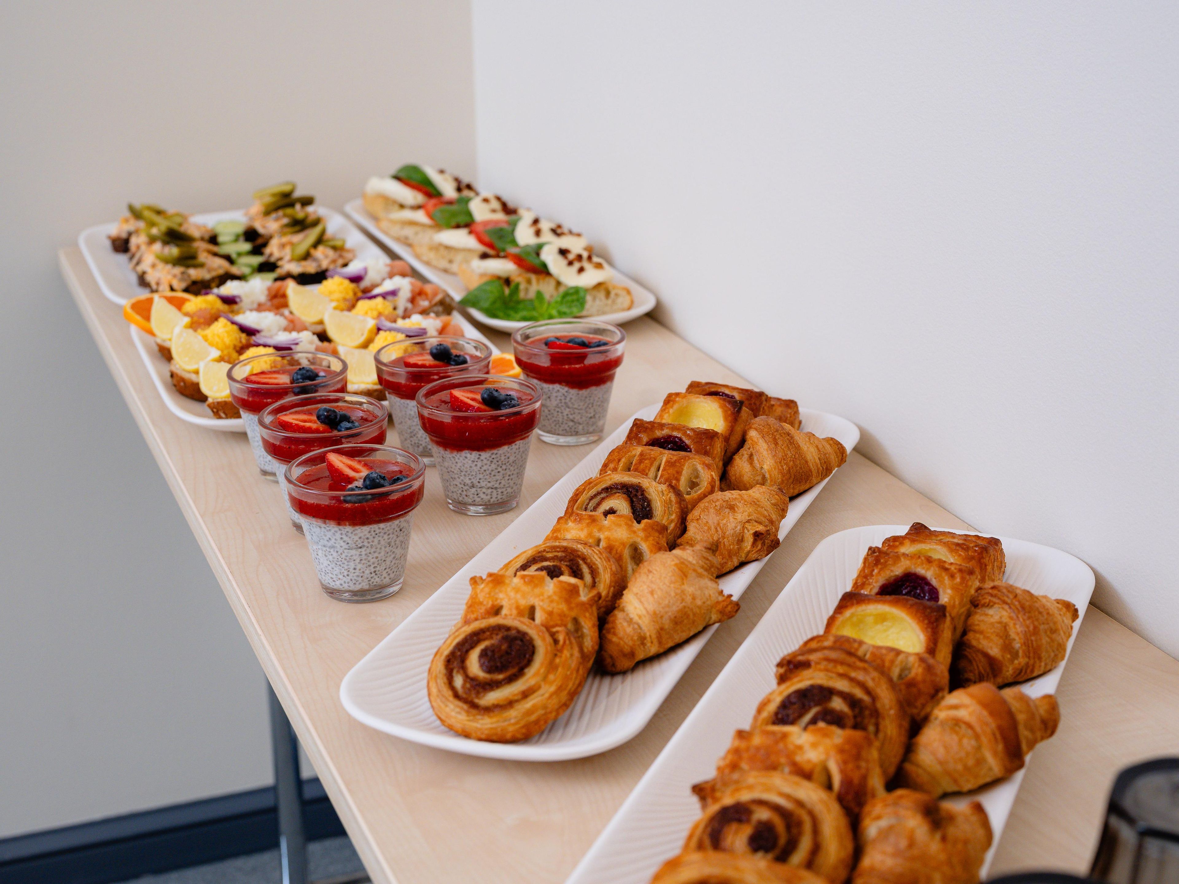 Een buffet met diverse gerechten, waaronder gebak, salades en desserts.