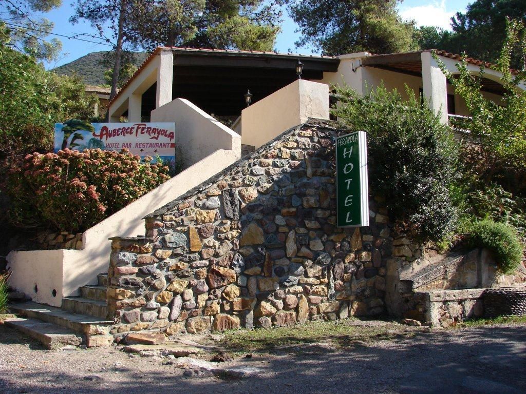 L’entrée d’un hôtel, avec un escalier en pierre menant à un bâtiment sur lequel est apposée une enseigne indiquant qu’il s’agit d’un hôtel.