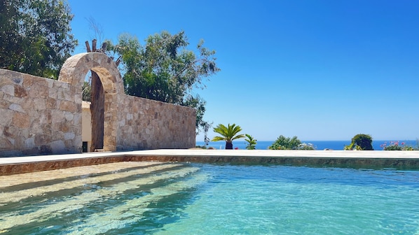 Een seizoensgebonden buitenzwembad en parasols bij het zwembad