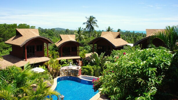 A resort with multiple bungalow-style buildings, a swimming pool, and lush tropical vegetation. - Wazzah Resort (Koh Samui)