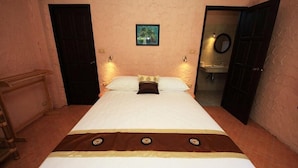 A single bed with a brown and white bedspread, a small framed picture above it, and a bathroom visible through an open door. - Wazzah Resort (Koh Samui)
