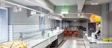 Una cocina moderna con una encimera larga, cestas de pan y una estación de café.