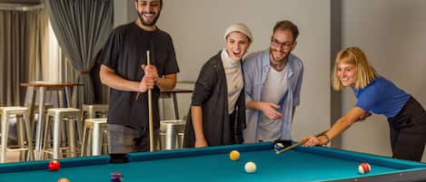 Ein Billardtisch mit mehreren Kugeln und einer Person, die Billard spielt.