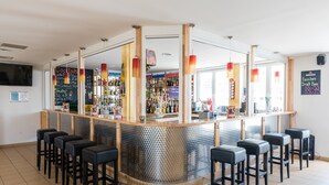 A bar area with a counter, stools, and a variety of bottles and glasses. - a&o Wien Hauptbahnhof (Vienna)