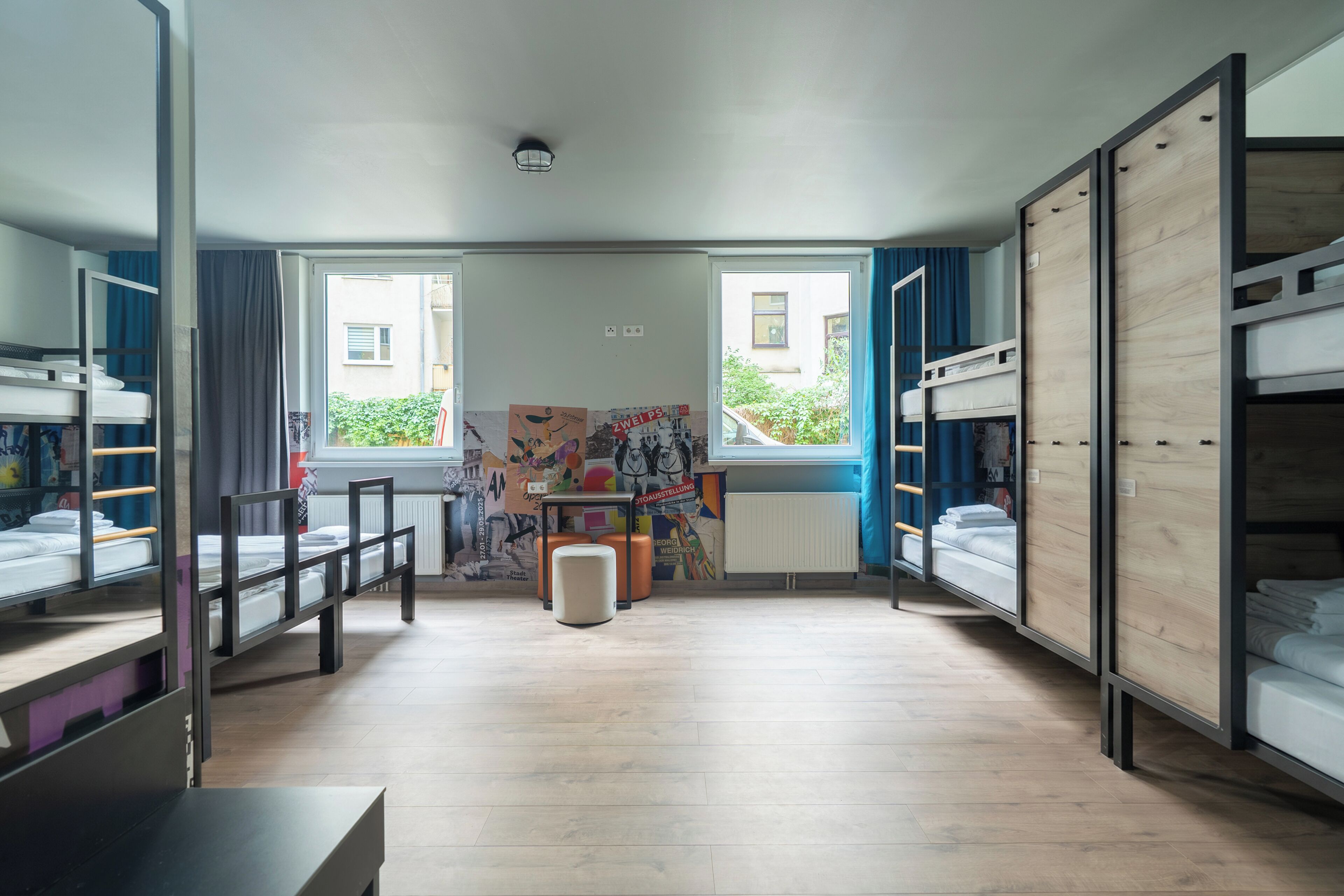 A room with bunk beds, a desk, and a radiator.