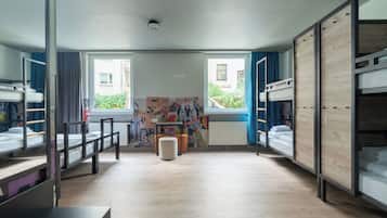 Ein Zimmer mit Etagenbetten, einem Schreibtisch und einer Heizung.