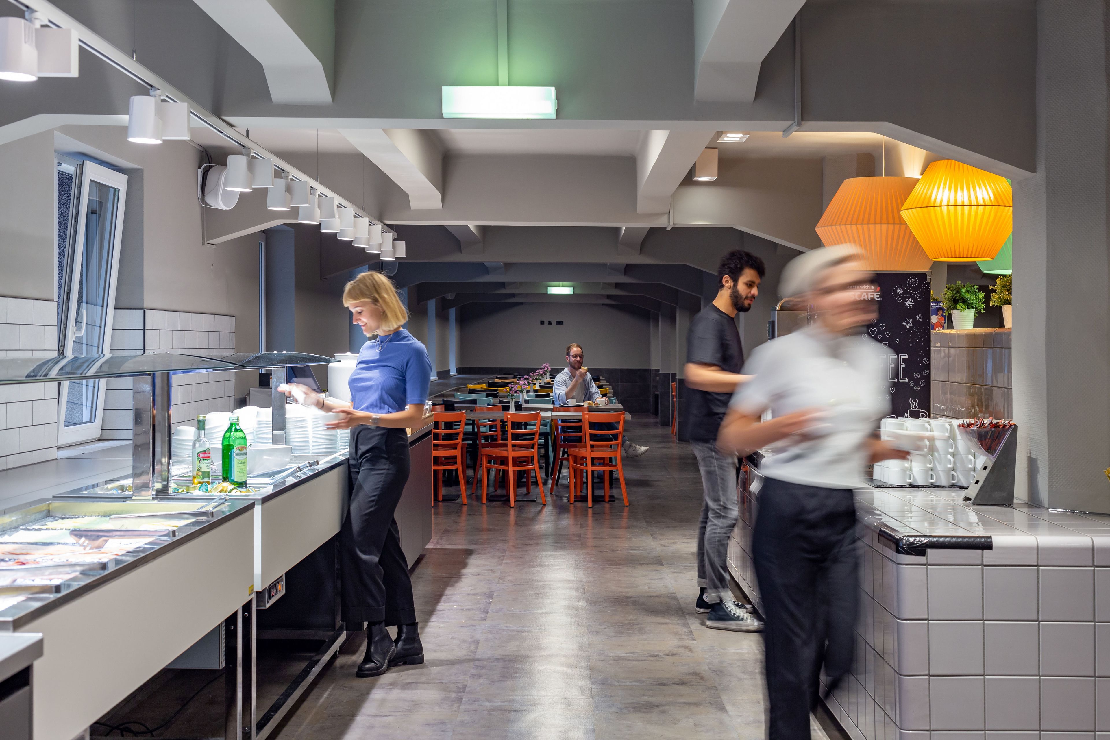 Une cuisine moderne avec un espace buffet, comprenant un comptoir où sont disposés les plats et un coin repas avec des tables et des chaises.