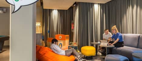 A kids' corner area with a bean bag, play area, and seating for adults.