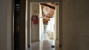 A hallway leading to a room with a sign reading "Cave del Sole Resort & Beauty". - Hotel Cave del Sole (Matera)