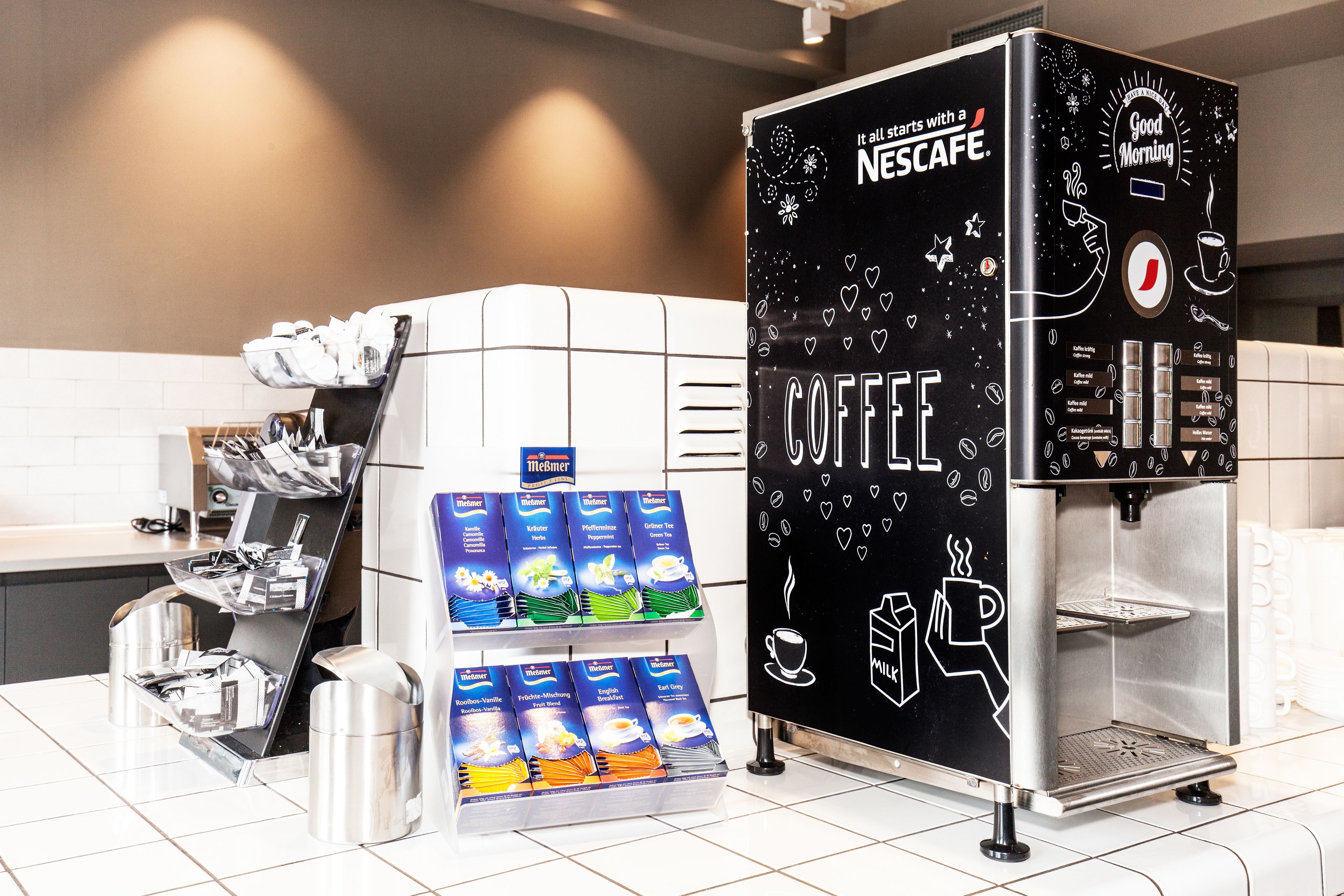Una cafetera con un expositor de cápsulas de café y una estación de café Nescafé.