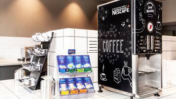 Una cafetera con un expositor de cápsulas de café y una estación de café Nescafé.