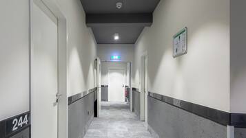 A hallway with doors numbered 244 and 241, a fire extinguisher, and a sign on the wall.