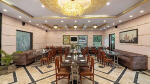 A spacious conference room with a long table, multiple chairs, and a chandelier. - Foxoso Taj View Hotel (Agra)