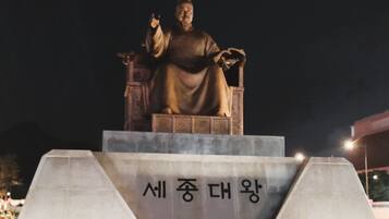 A statue on a pedestal with inscriptions.
