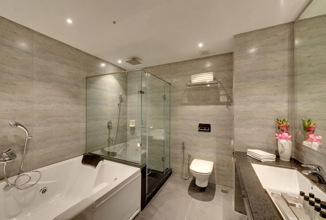 A modern bathroom with a glass-enclosed shower, a separate toilet, and a bathtub.