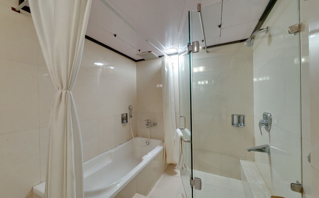 Un baño moderno con bañera, cabina de ducha de vidrio y puerta de vidrio.