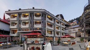 A multi-story hotel with outdoor seating and a sign reading "Way to Life". - Hotel Combermere (Shimla)