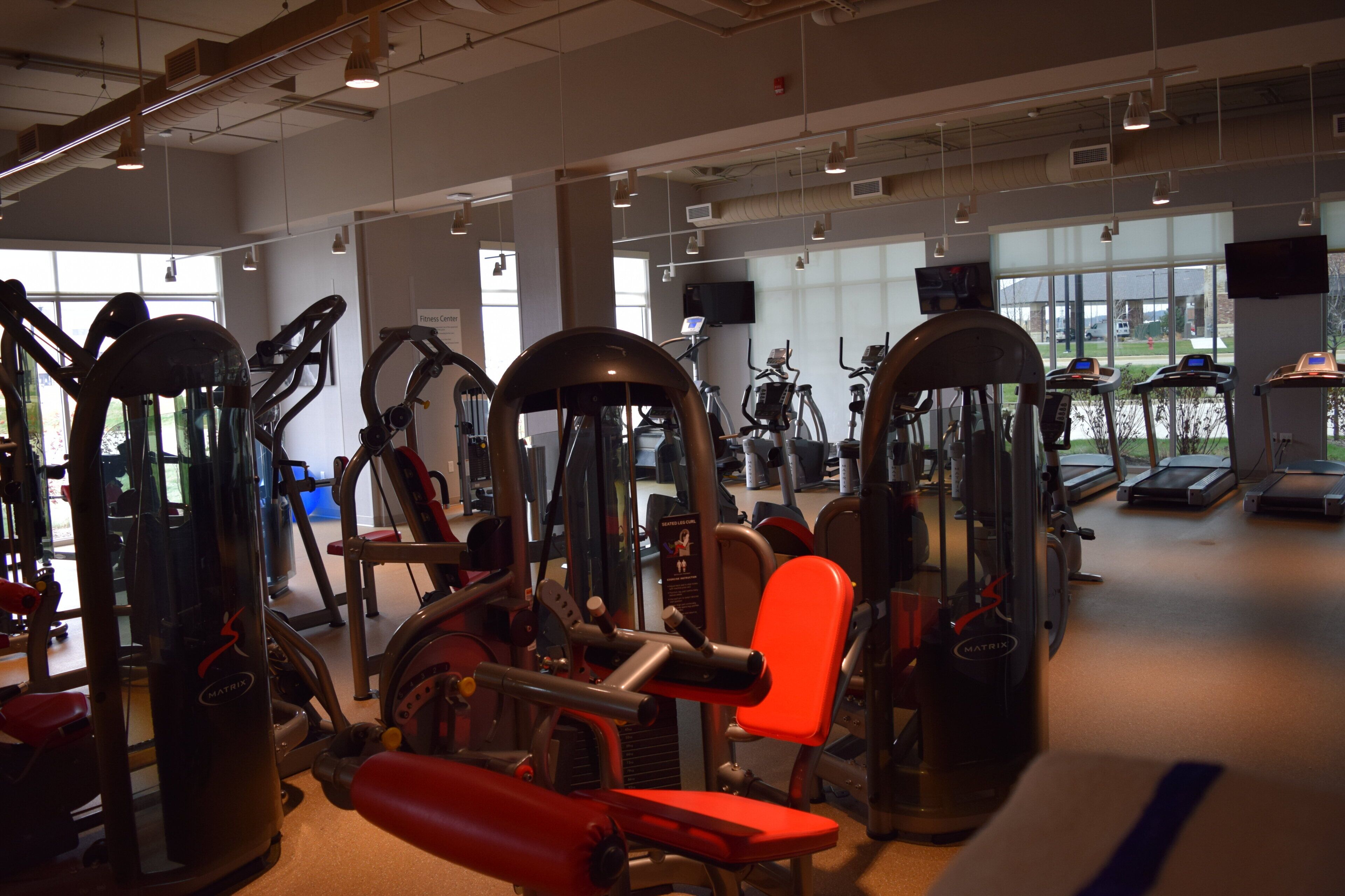 A gym with various exercise equipment, including treadmills and weight machines.