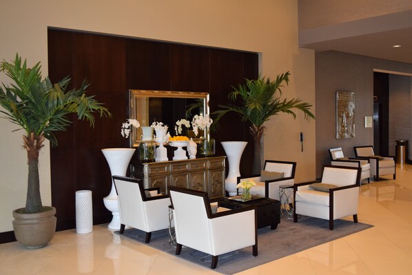 A lobby with a reception desk, seating area, and decorative plants. - Holiday Inn Hotel & Suites East Peoria by IHG (East Peoria)