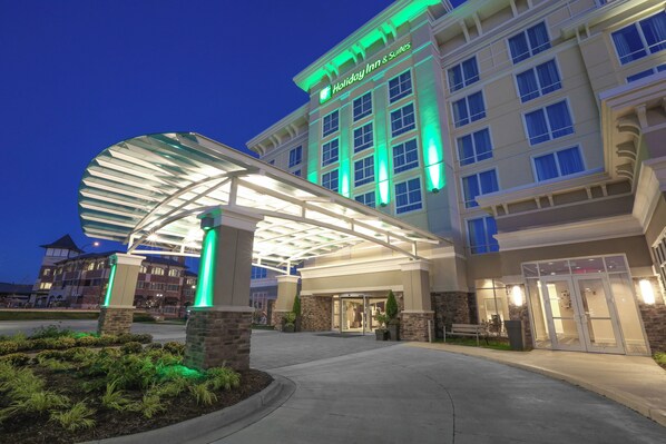 Un Holiday Inn & Suites con entrada cubierta y fachada de ladrillo.