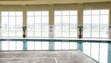 Una piscina techada, sillones reclinables de piscina