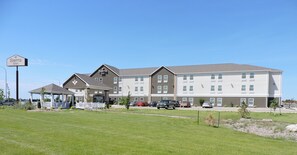 A multi-story hotel with a covered entrance and a parking lot. - Spark by Hilton Minot (Minot)