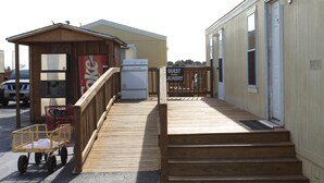 A guest laundry facility with a wooden deck and a refrigerator. - Cotulla Homes (Cotulla)