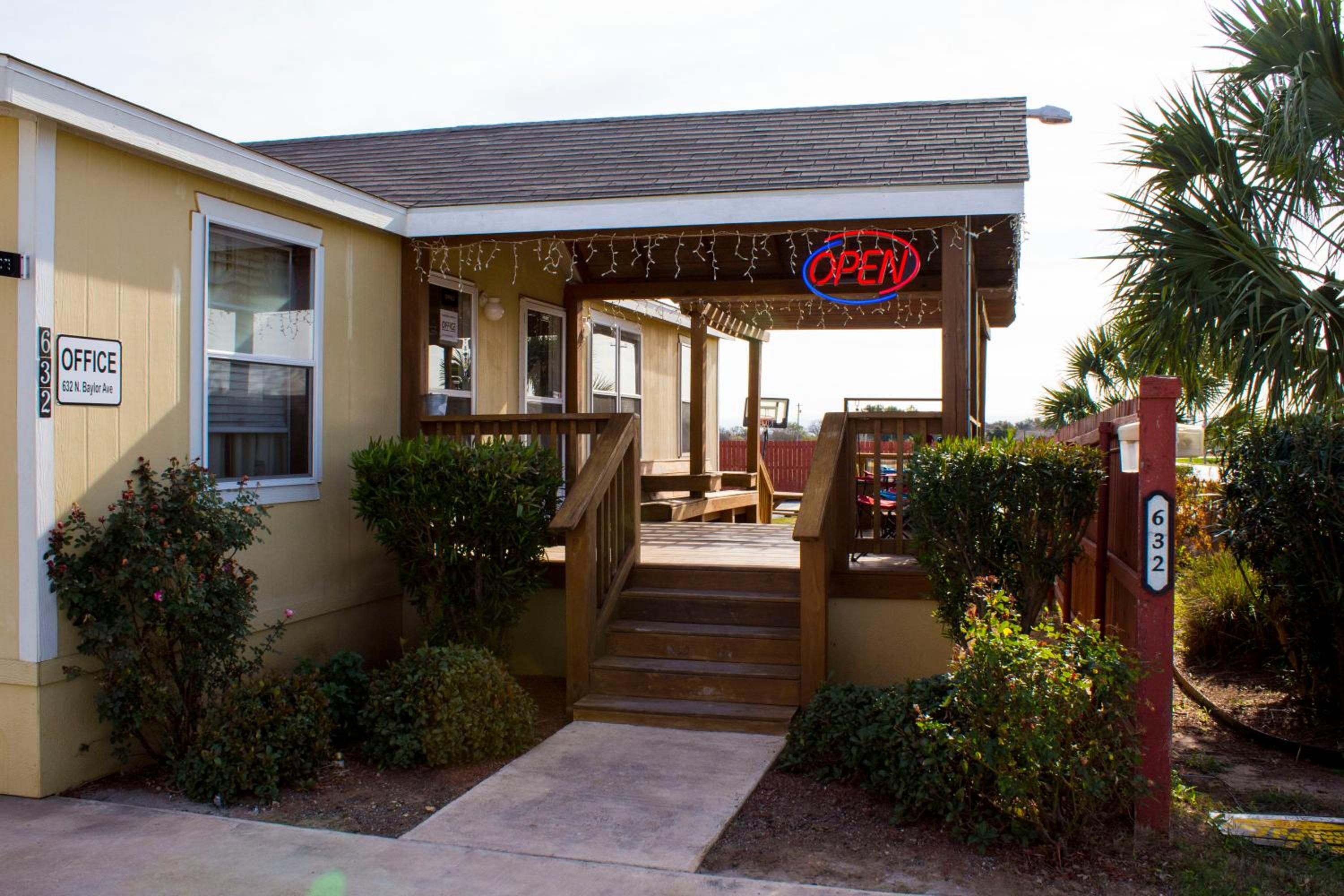 A building with a porch, a staircase, and a sign indicating an office.