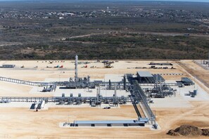 An industrial facility with multiple buildings, storage tanks, and pipelines. - Cotulla Homes (Cotulla)