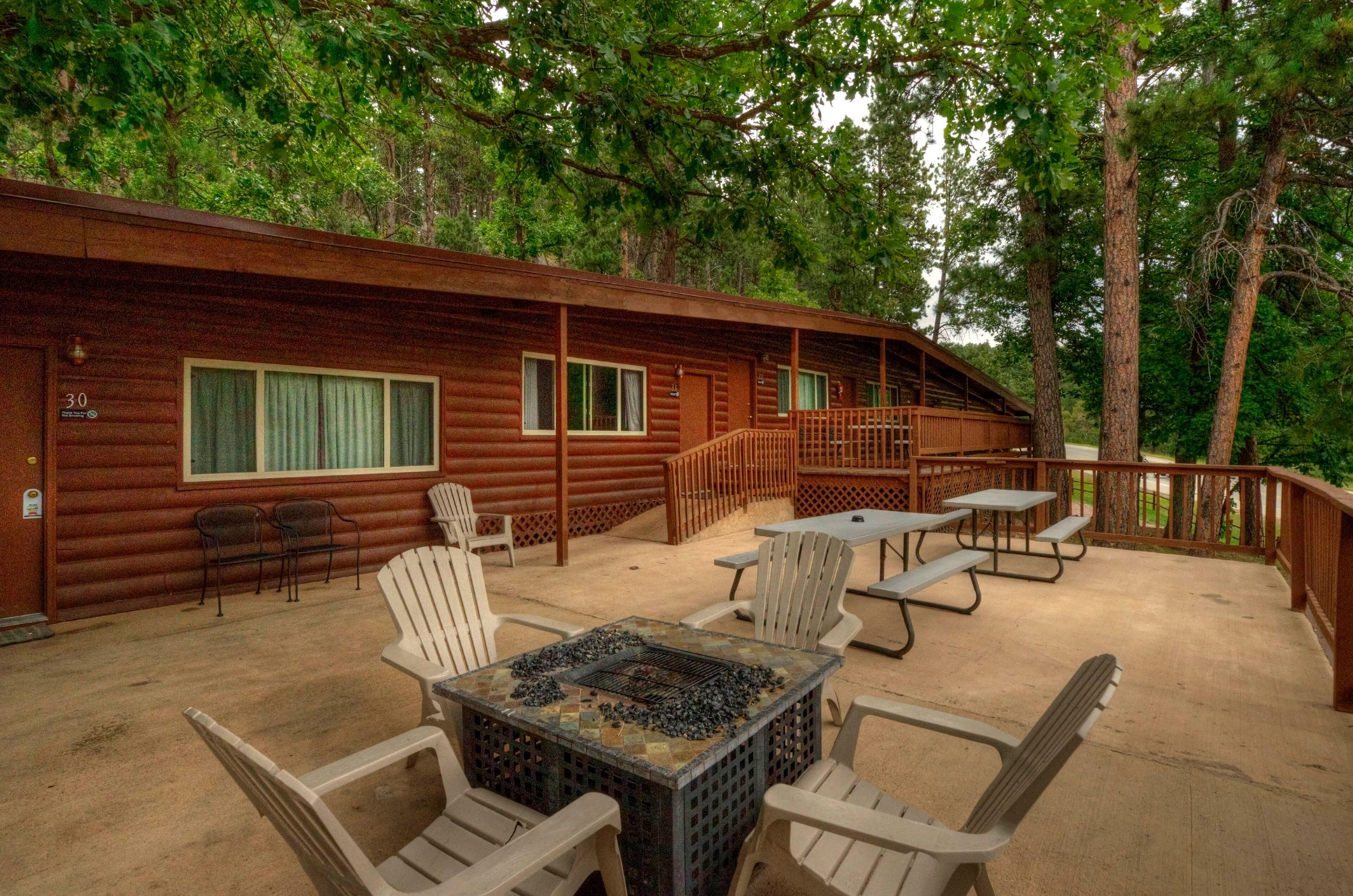 A cabin with a patio area featuring outdoor seating and a grill.