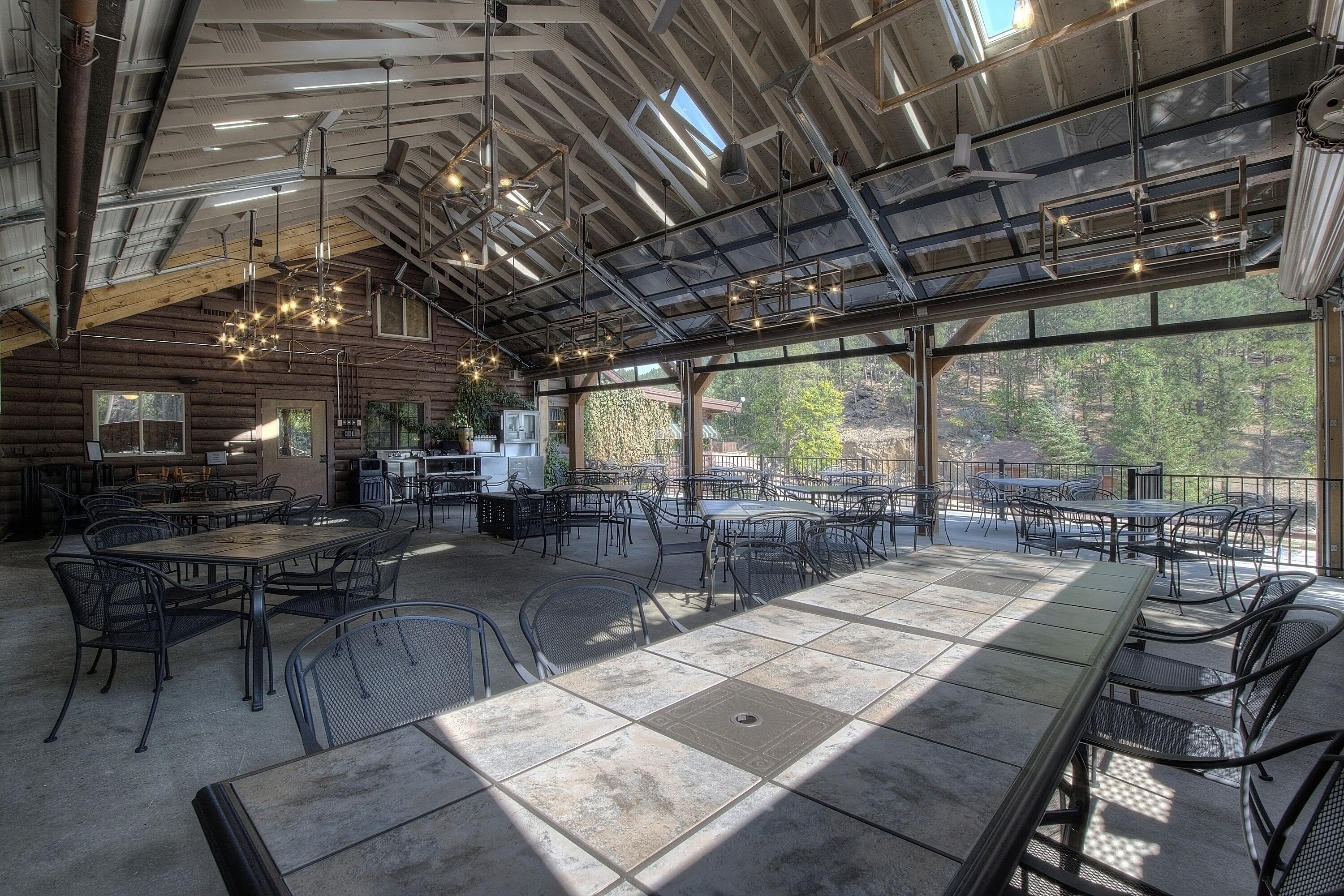 A spacious indoor dining area with high ceilings, large windows, and modern lighting fixtures.