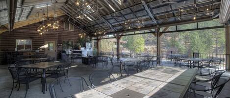 A spacious indoor dining area with high ceilings, large windows, and modern lighting fixtures.