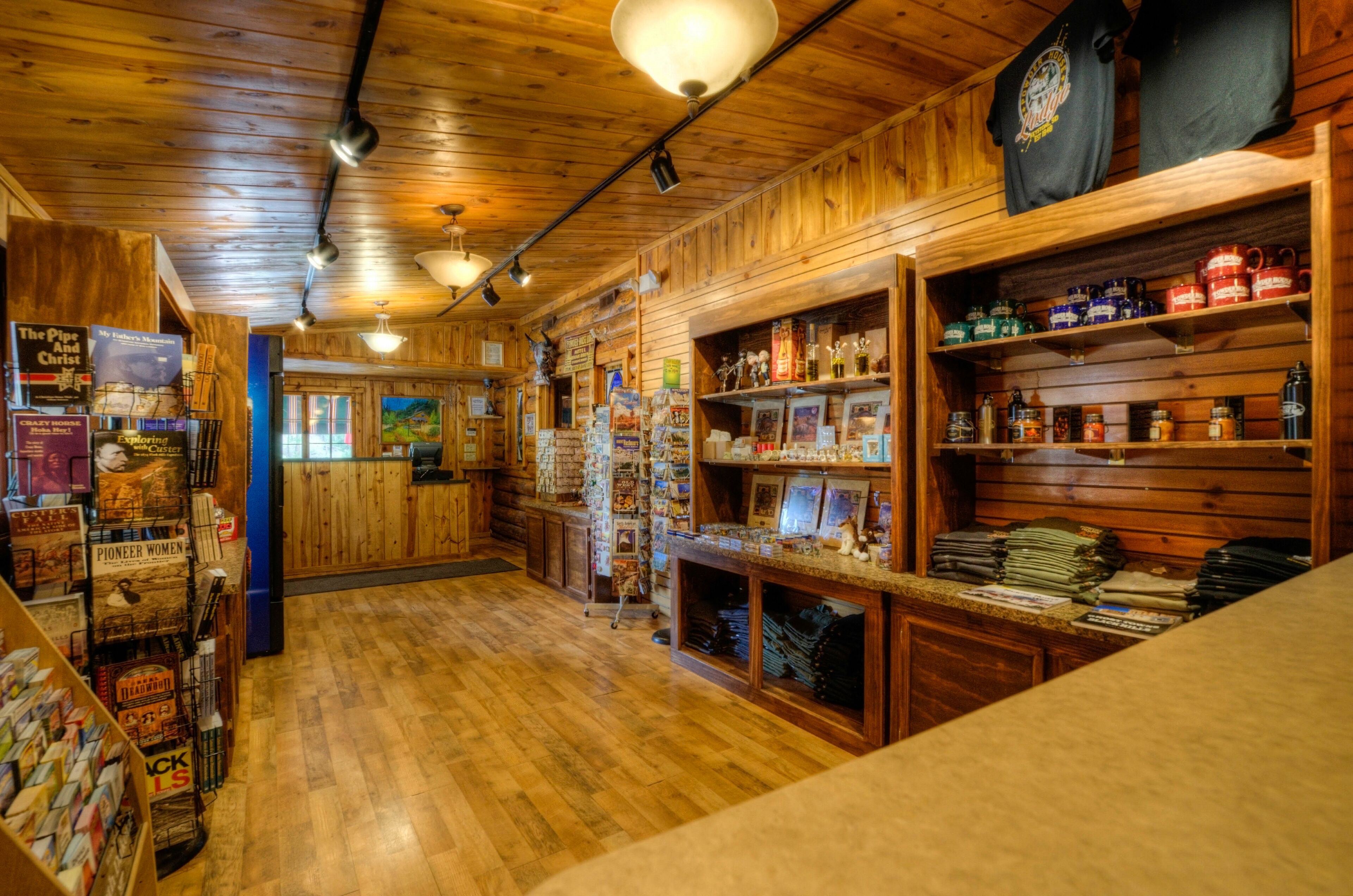 A cozy, wooden-themed bookstore with shelves of books and magazines, a counter with various items, and a rustic interior.