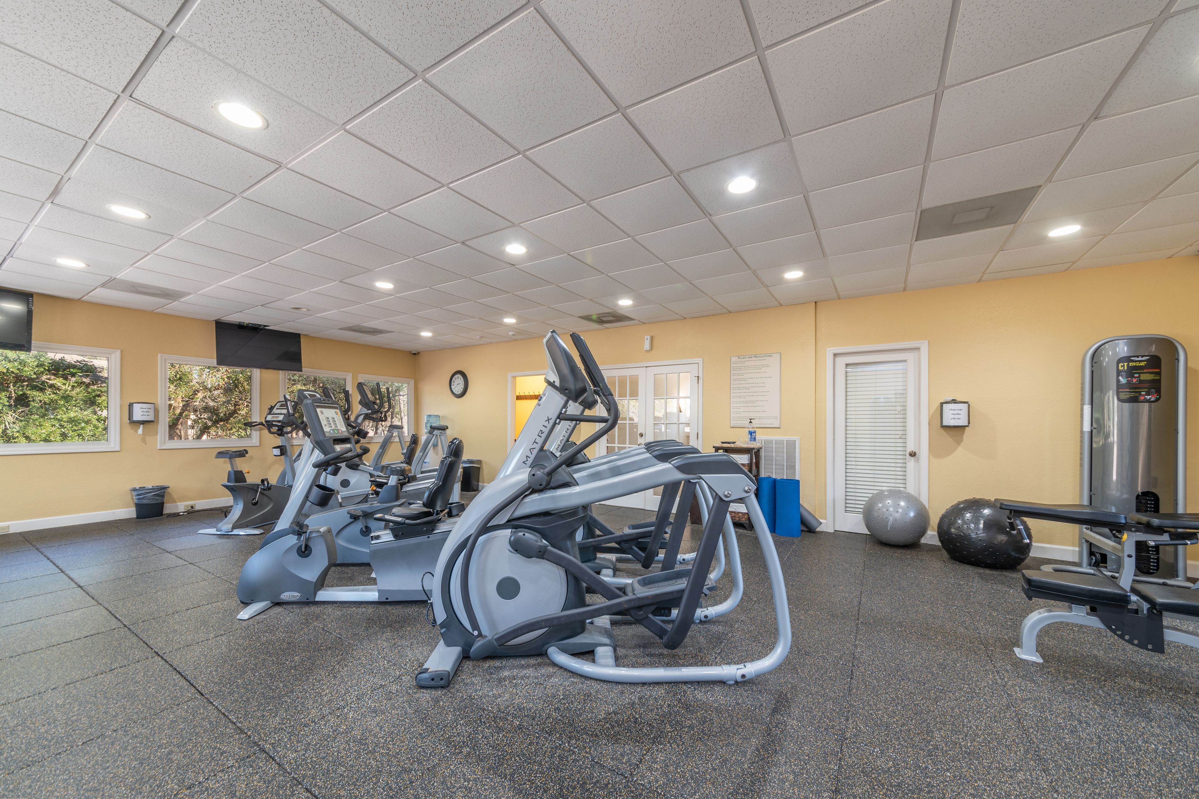 A gym with stationary bikes, elliptical machines, and free weights.