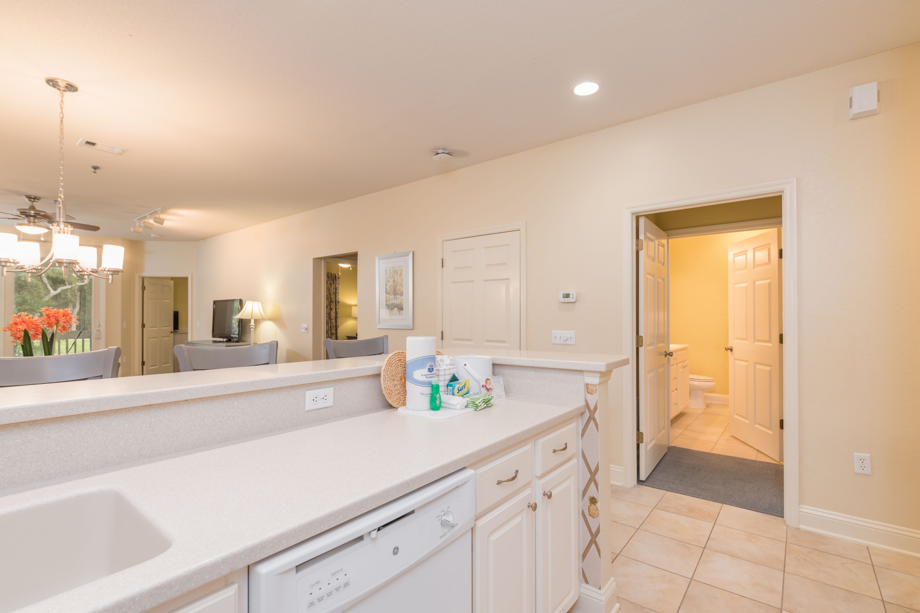 A kitchen with a large island, white cabinets, and a ceiling fan.