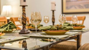 Une table à manger dressée avec des assiettes, des verres et une bougie.